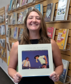 Photo of Anna Bohren holding the book "Living in Wyoming: Settling for More."