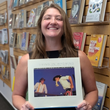 Photo of Anna Bohren holding the book "Living in Wyoming: Settling for More."